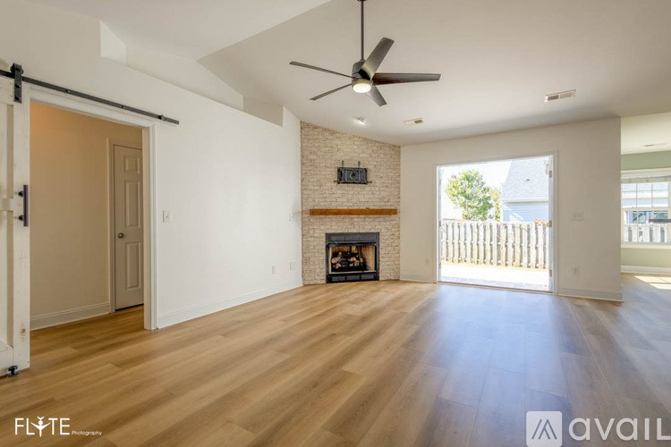 A spacious living room with a fireplace and sliding glass doors.