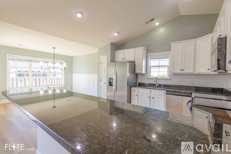 A kitchen with granite countertops and white cabinets.