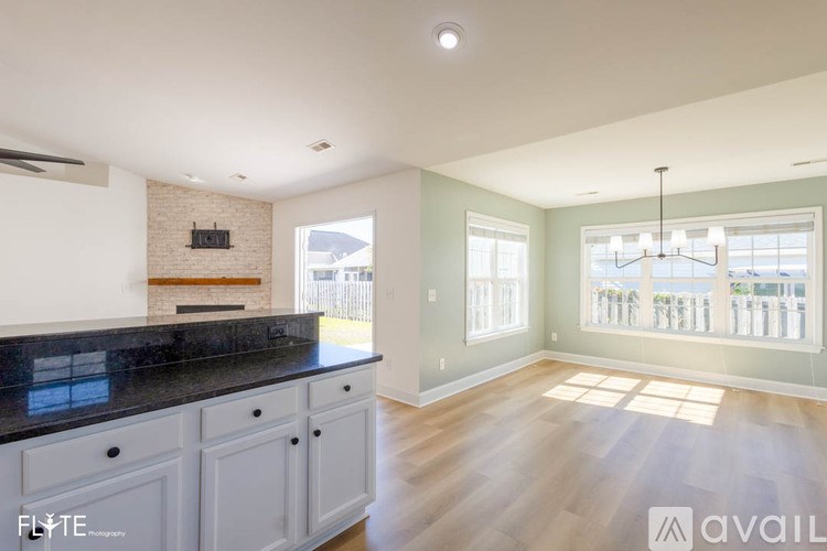A kitchen with a black countertop and white cabinets.
