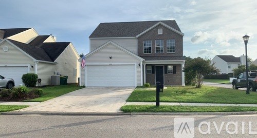 A house with a garage and a driveway in front of it.