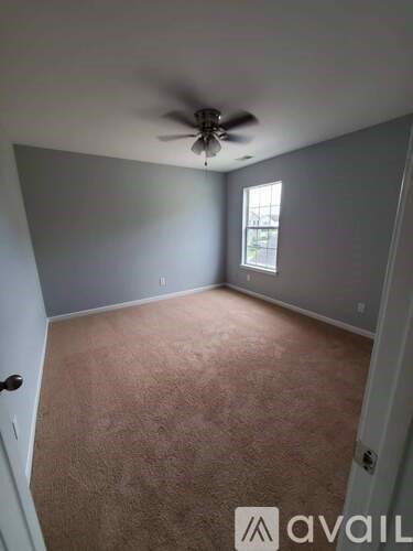 A room with a ceiling fan and a window.