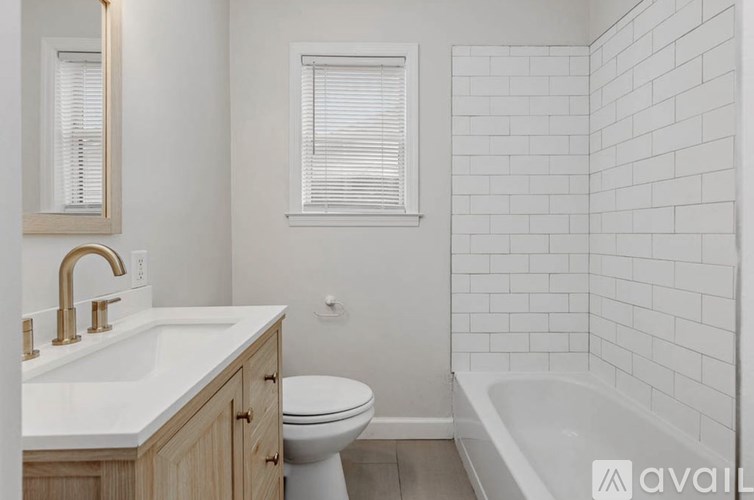 A white bathroom with a tub, toilet, and sink.