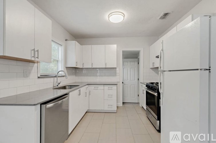 A kitchen with white cabinets and appliances.