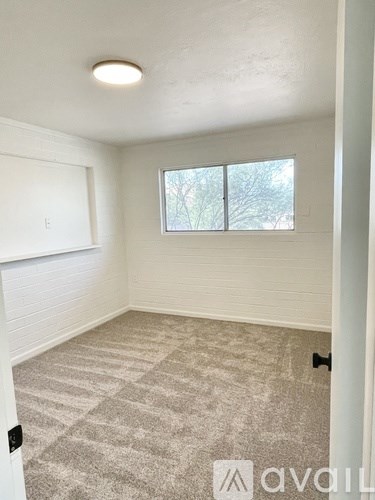 A room with a carpeted floor and a window.