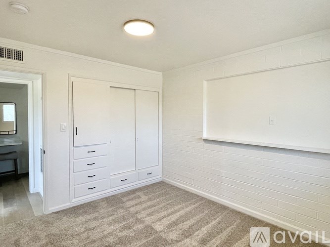 A white closet with drawers and a white door.