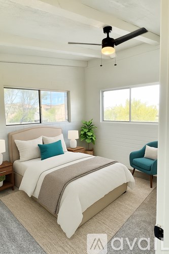 A bedroom with a large bed and a ceiling fan.