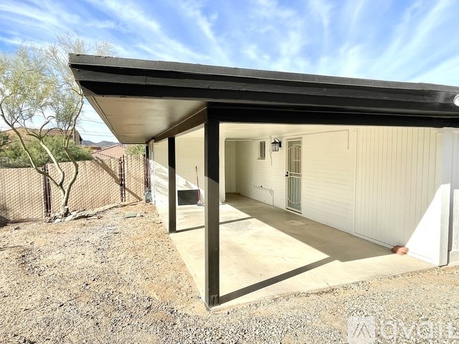 A small white building with a black roof and a door.