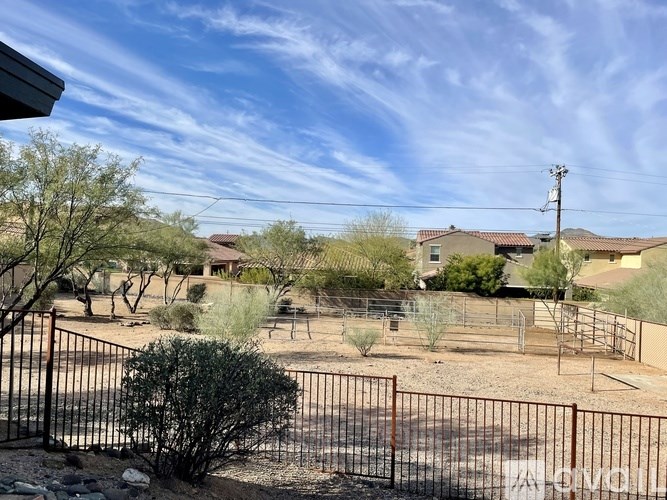 A fenced yard with a house in the background.