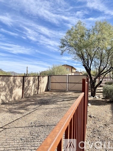 A brown fence with a gate stands in front of a house.