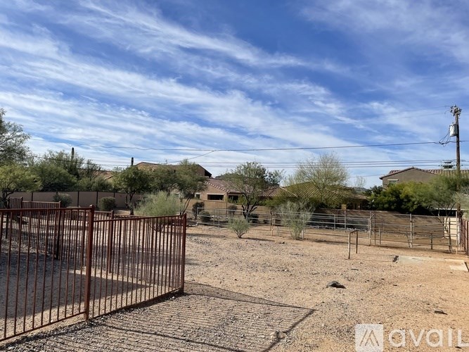 A gate blocks the entrance to a dirt lot.