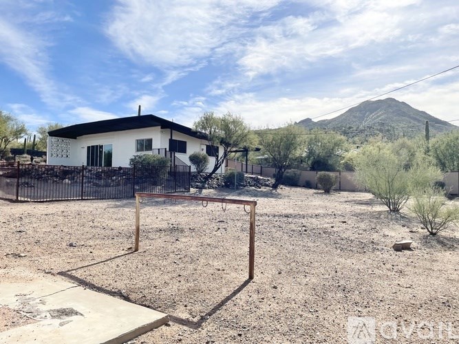 A house with a yard and a mountain in the background.