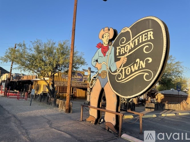 A sign for Frontier Town with a cowboy holding a lasso.