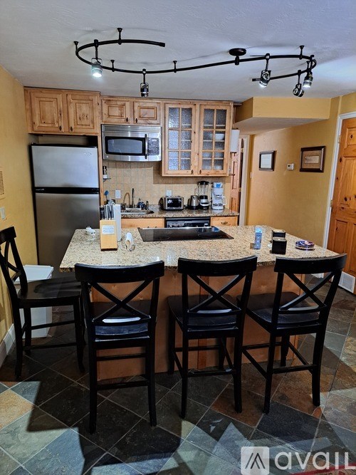 A kitchen with a table and chairs in the middle.