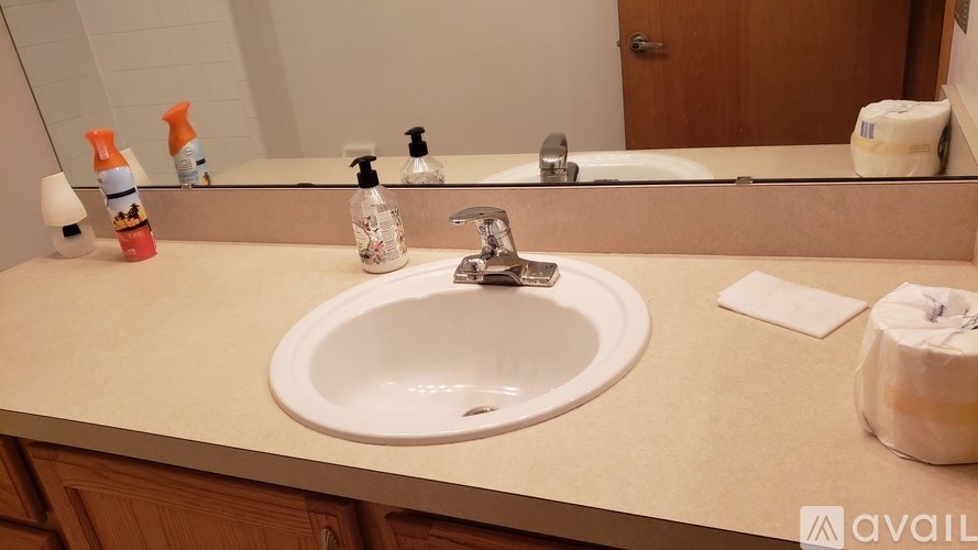 A bathroom sink with a white countertop and a mirror above it.