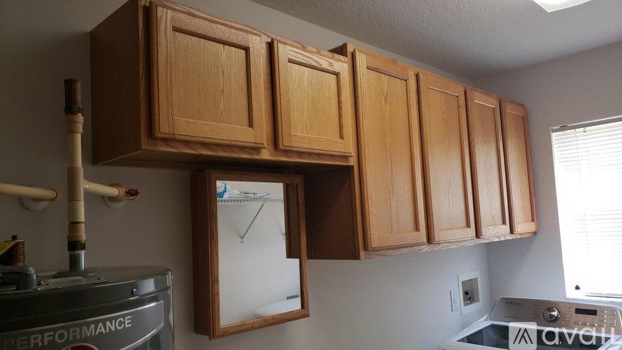 A kitchen with wooden cabinets and a white wall.