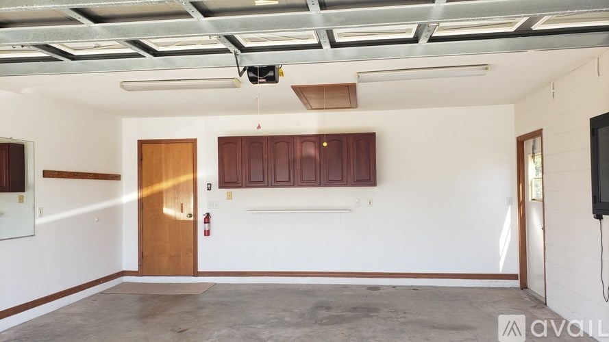 A room with a white wall and a brown door.