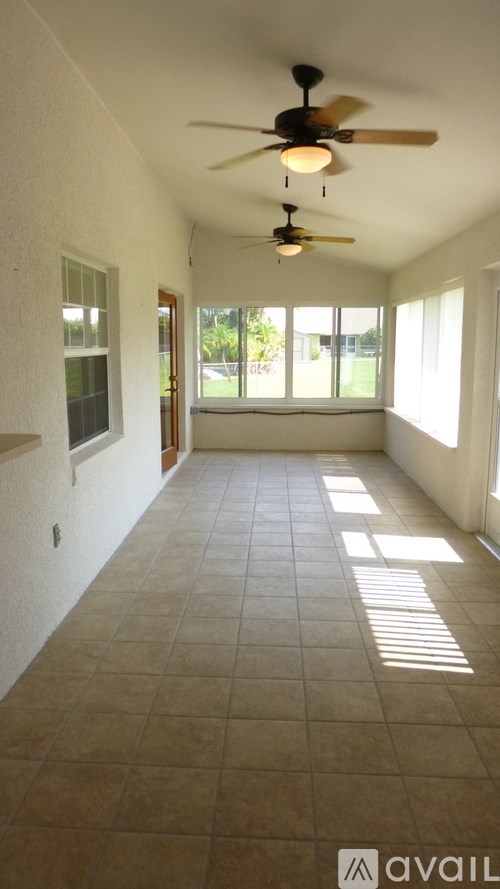 A room with a ceiling fan and tiled flooring.