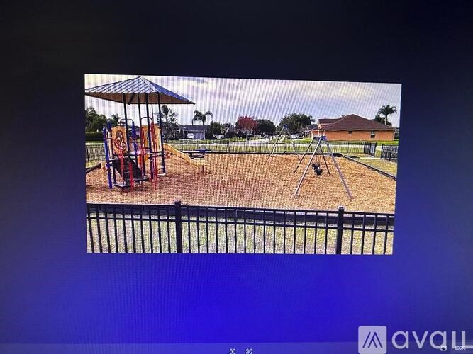 A playground with a swing set and a blue sky.