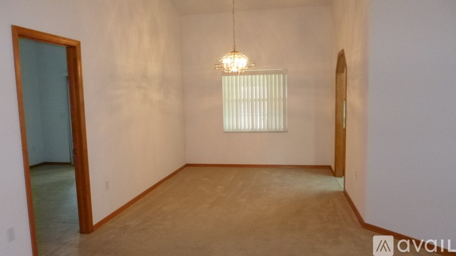 A room with a wooden floor and a chandelier hanging from the ceiling.