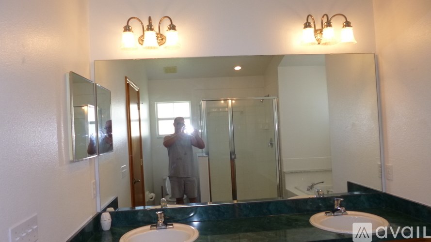 A man is taking a picture of a bathroom in a mirror.