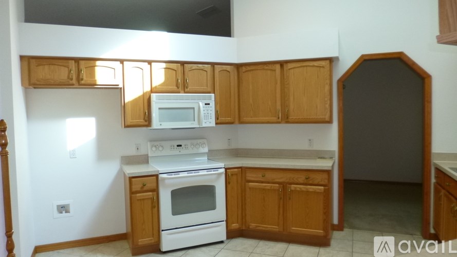 A kitchen with wooden cabinets and white appliances.