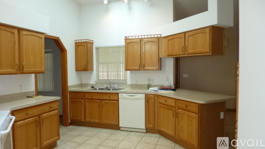 A kitchen with wooden cabinets and a white dishwasher.