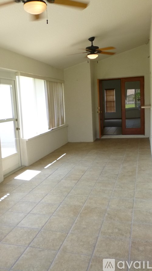 A room with a ceiling fan and tiled floor.
