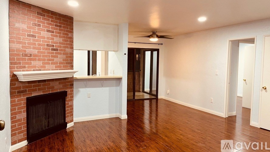 A room with a fireplace and a ceiling fan.