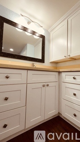 A mirror is mounted above a white cabinet.