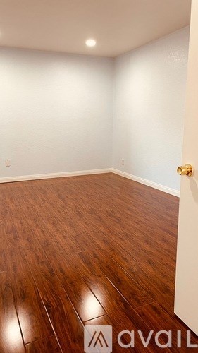 A room with wooden flooring and a white wall.