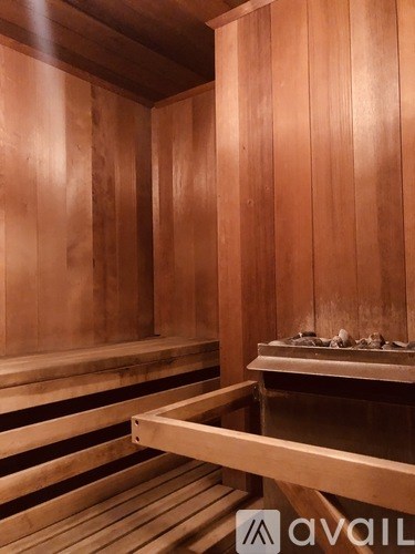 A wooden sauna with benches and a stone hot plate.