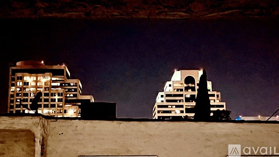 Two buildings are lit up at night.