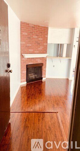 A room with a fireplace and wooden floors.