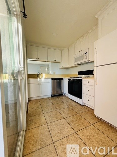 A kitchen with white appliances and cabinets.