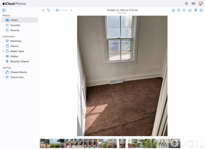 A room with a window and a brown carpet.