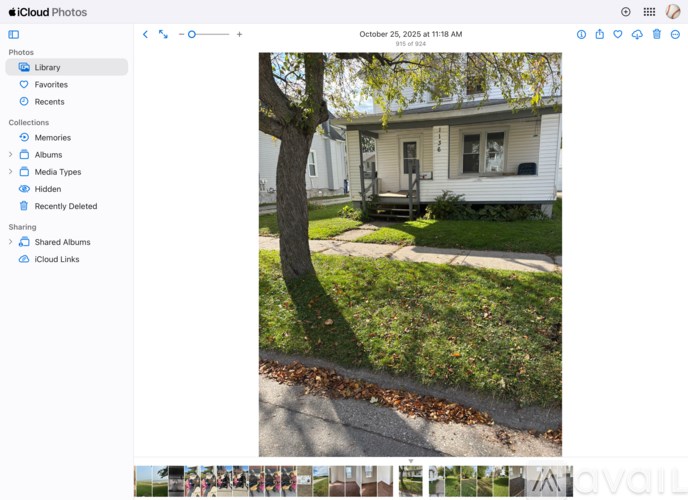 A white house with a tree in front of it.