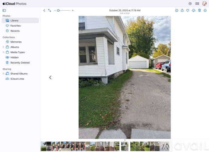 A white house with a gravel driveway in front.