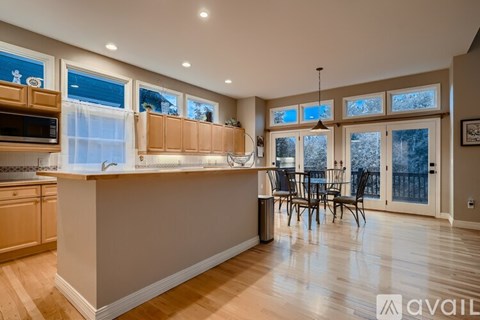 A kitchen with wooden cabinets and a large island with a sink.