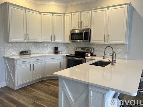 A kitchen with white cabinets and a white countertop.