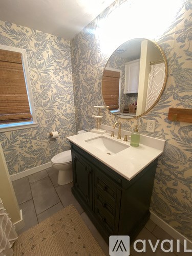 A bathroom with a sink, toilet and mirror.