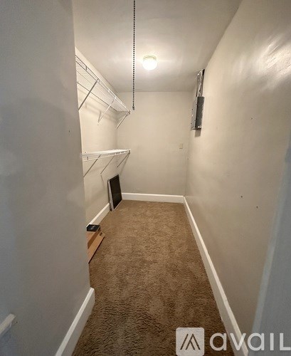 A small, empty room with a carpeted floor and white walls.