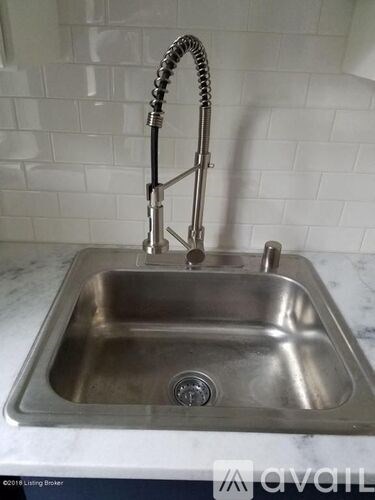 A stainless steel kitchen sink with a faucet and a hose attached to it.