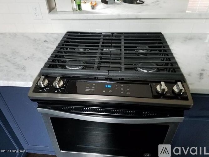 A modern black stove top with four burners and a digital control panel.