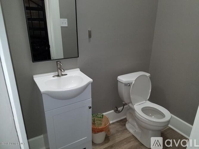 A white toilet sits next to a white sink in a bathroom.
