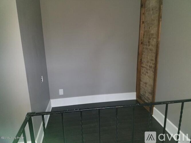 A room with a glass railing and a wooden board on the wall.