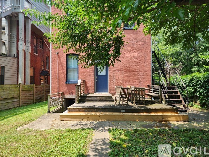 A red brick house with a blue door and a wooden deck.