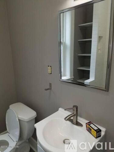 A bathroom with a toilet, sink, and medicine cabinet.