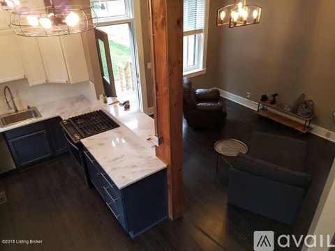 A kitchen with a marble countertop and a black stove top oven.