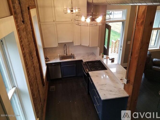 A kitchen with a marble countertop and a brick wall.