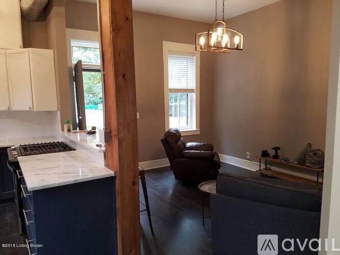 A kitchen with a marble countertop and a brown leather chair.
